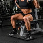 Hack Squat Machine Guide: EMG Research, How It Differs From the Barbell Squat, and Technique person performing hack squat machine correct form full depth parallel back against pad shoulder width feet gym leg training photography