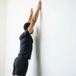 person performing shoulder mobility exercise wall slide overhead reach scapular upward rotation flexibility training
