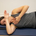 person performing sleeper stretch side-lying shoulder internal rotation GIRD posterior capsule